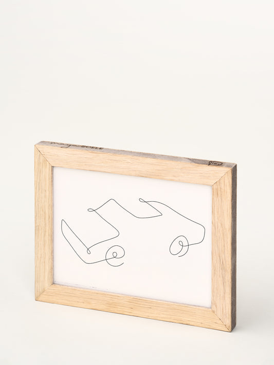 Lykønskningskortet i en elegant træramme, set fra en skrå vinkel, der fremhæver design og materialekvalitet.